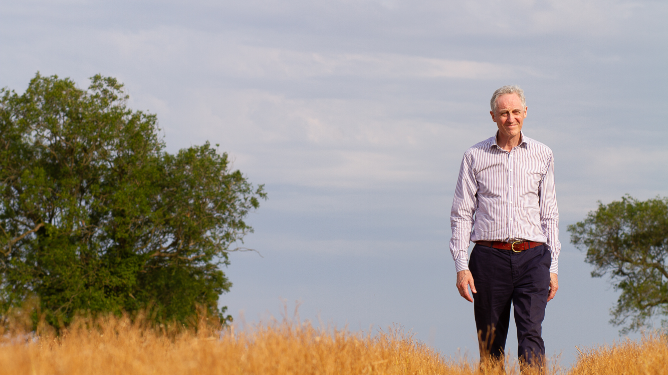 Man standing in a field with trees