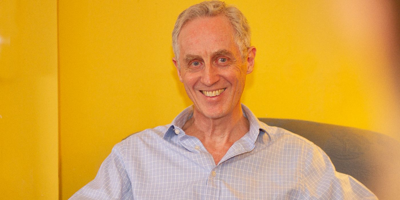 Man sitting in chair facing camera and smiliing