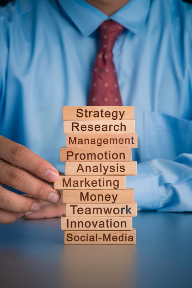 Midsection of businessman holding toy blocks with text on table